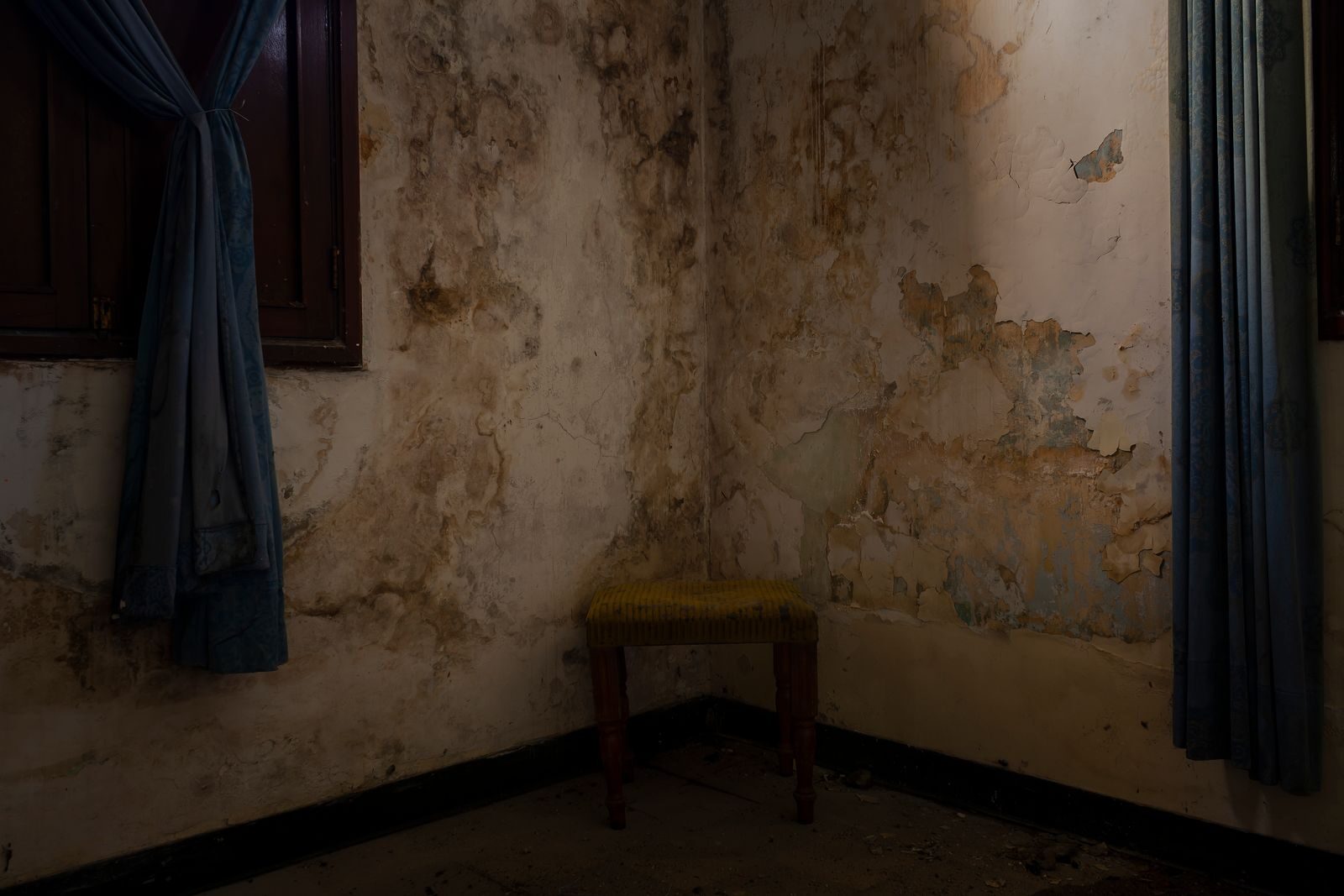 Dark mould and damp spread across an indoor wall corner, the deeper stage people call mould
