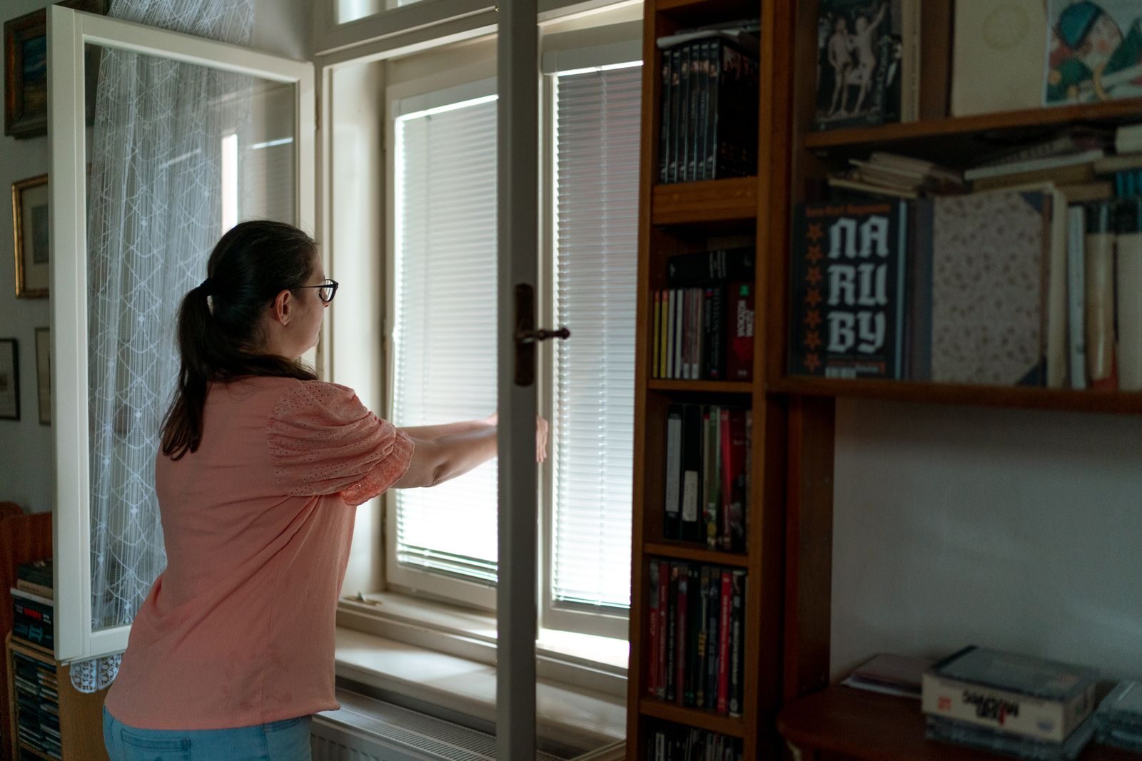 A person opening a window in a home to air a room with a quick burst of fresh airImage title: Opening a window to air a room