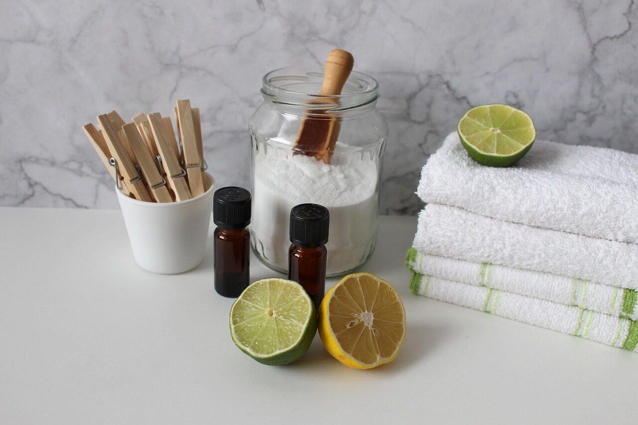 Natural cleaning staples including baking soda, citrus, and essential oil bottles on a counter