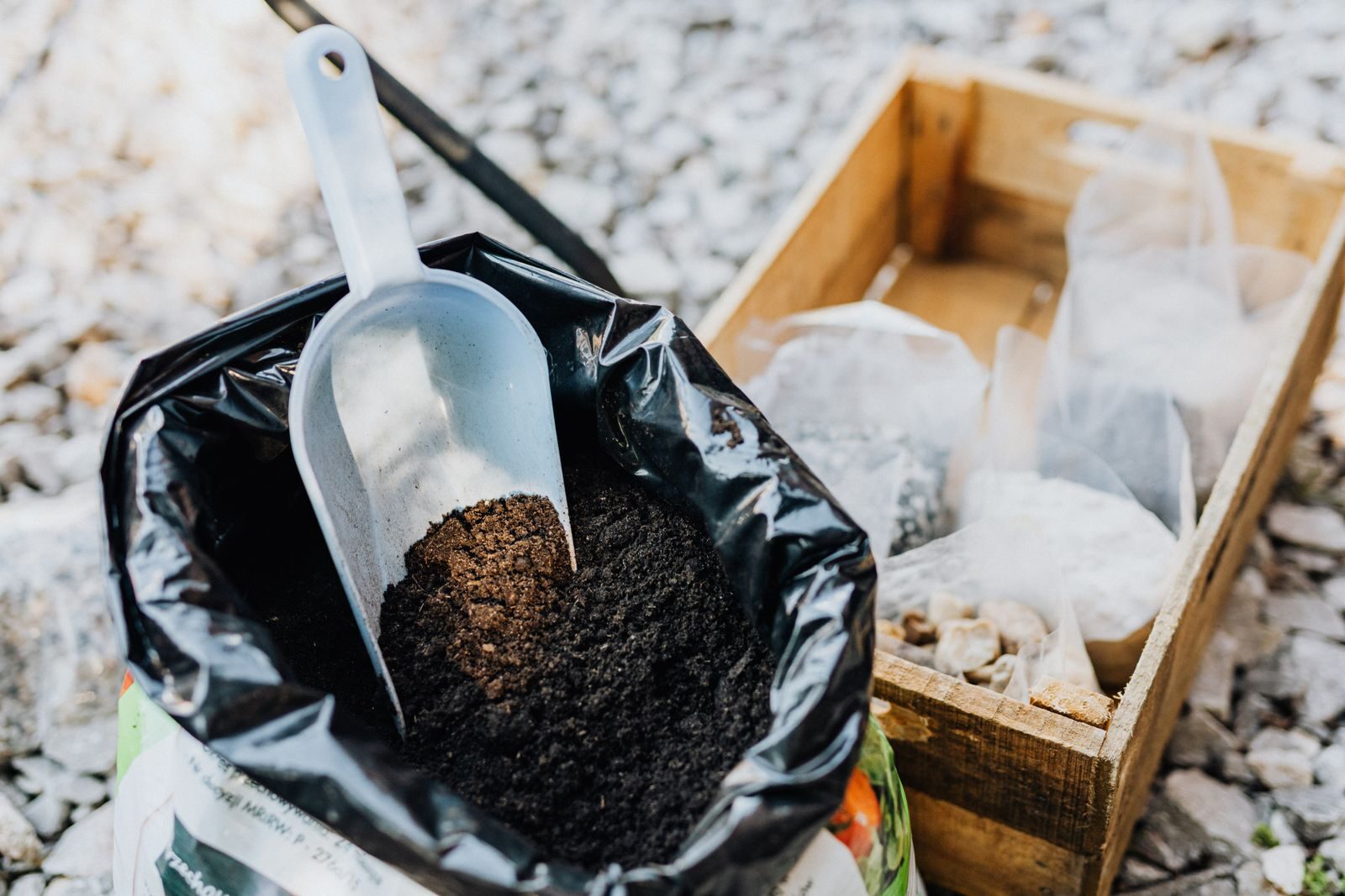 Dark compost soil in a bag with a scoop showing organic decomposed material for garden use