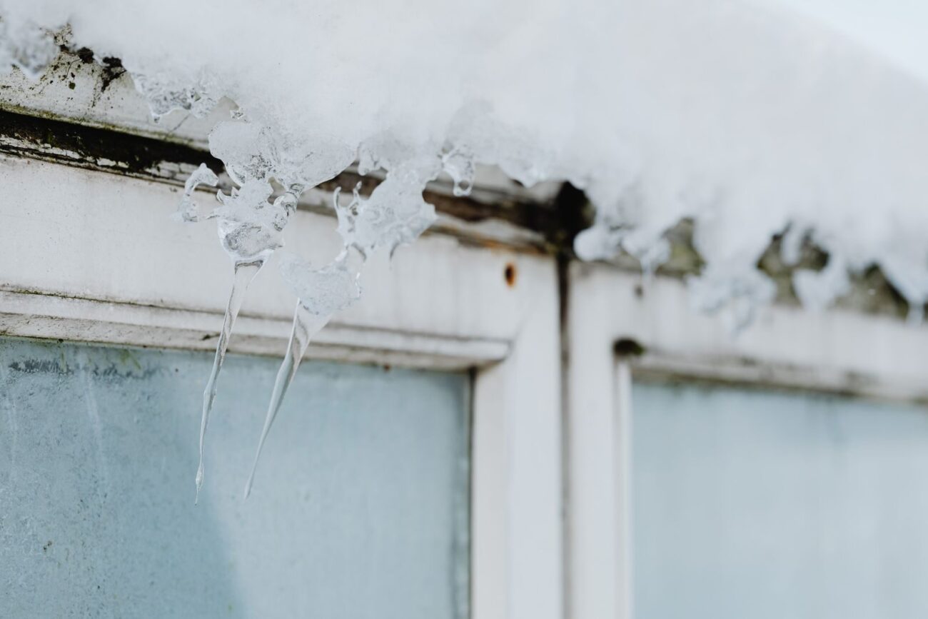 A home window covered in snow and ice in winter, when condensation and damp build up indoors