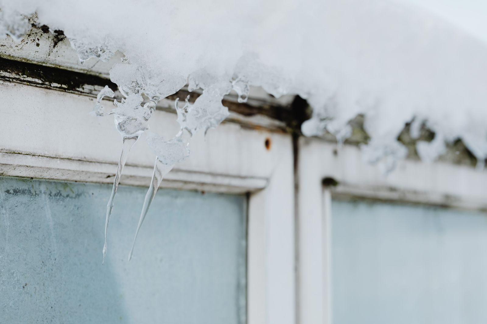 A home window covered in snow and ice in winter, when condensation and damp build up indoors