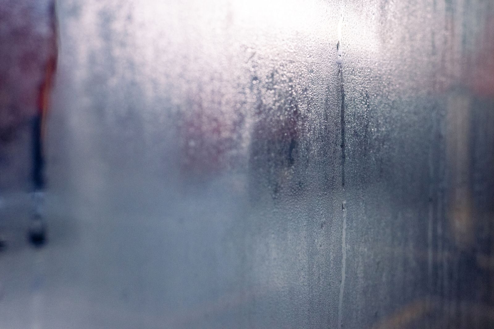 Condensation and water droplets on a misted window, the kind of winter damp a PIV unit is meant to reduce