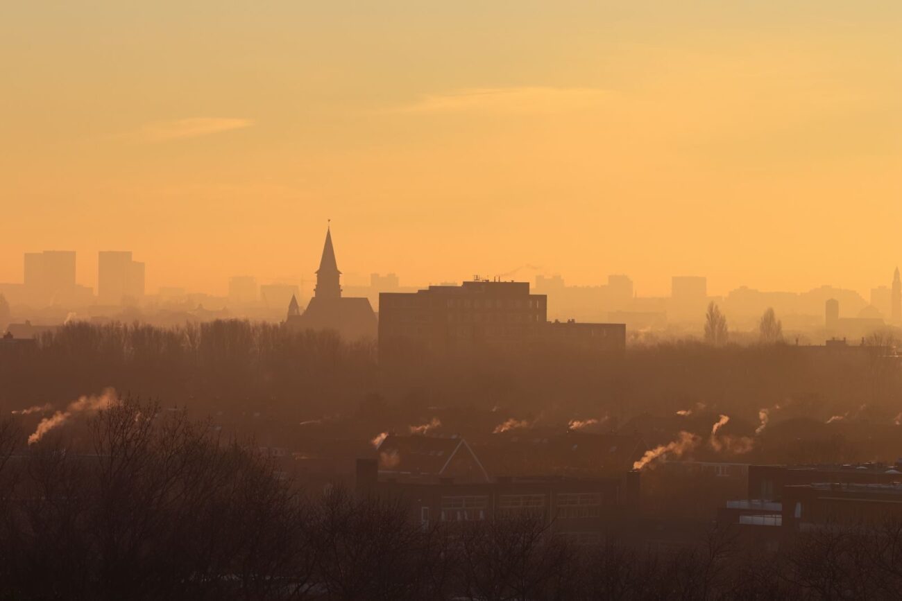 Hazy orange sky over a smoke-filled city skyline