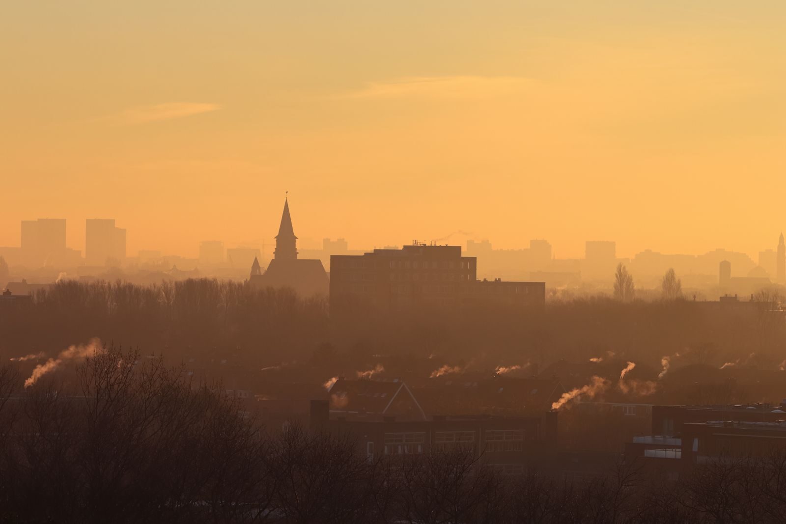 Hazy orange sky over a smoke-filled city skyline