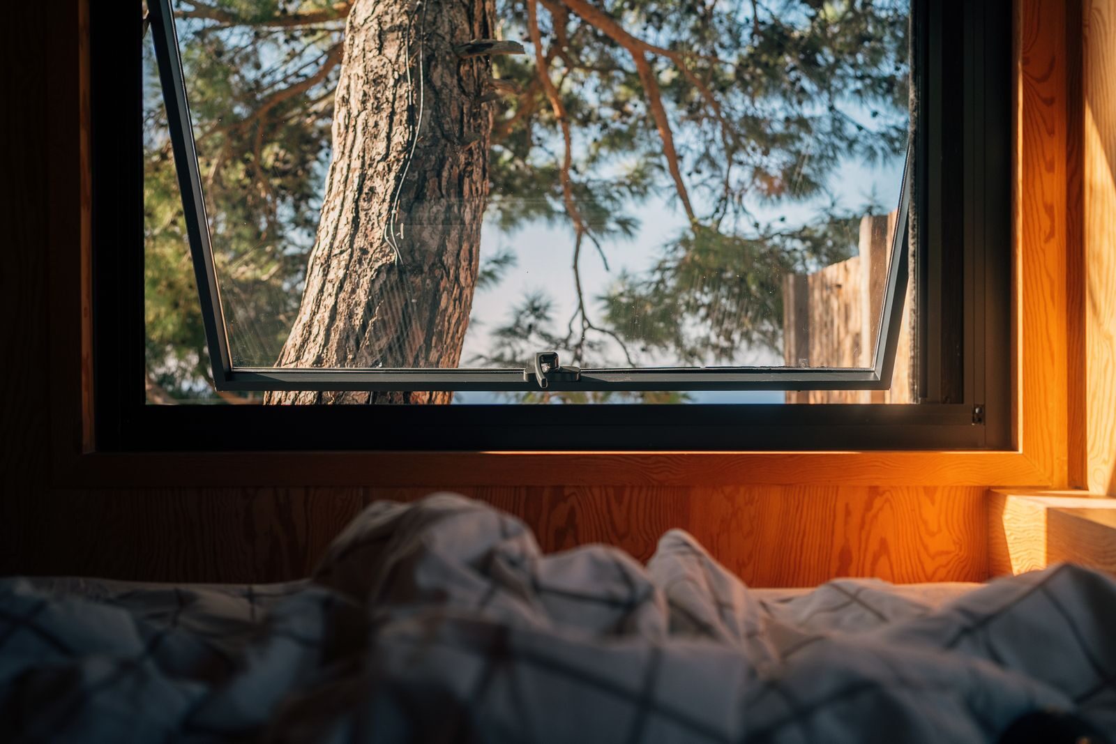 Open bedroom window at dusk for summer cooling