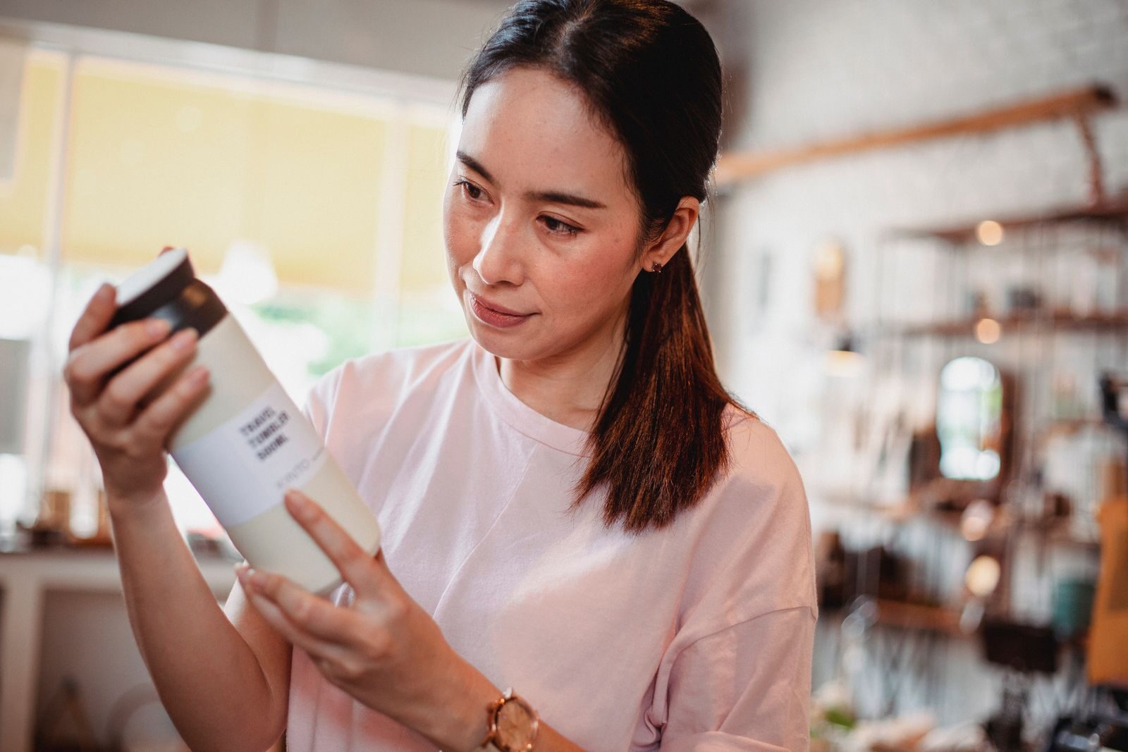 A shopper reading the ingredient label on a cleaning product before buying