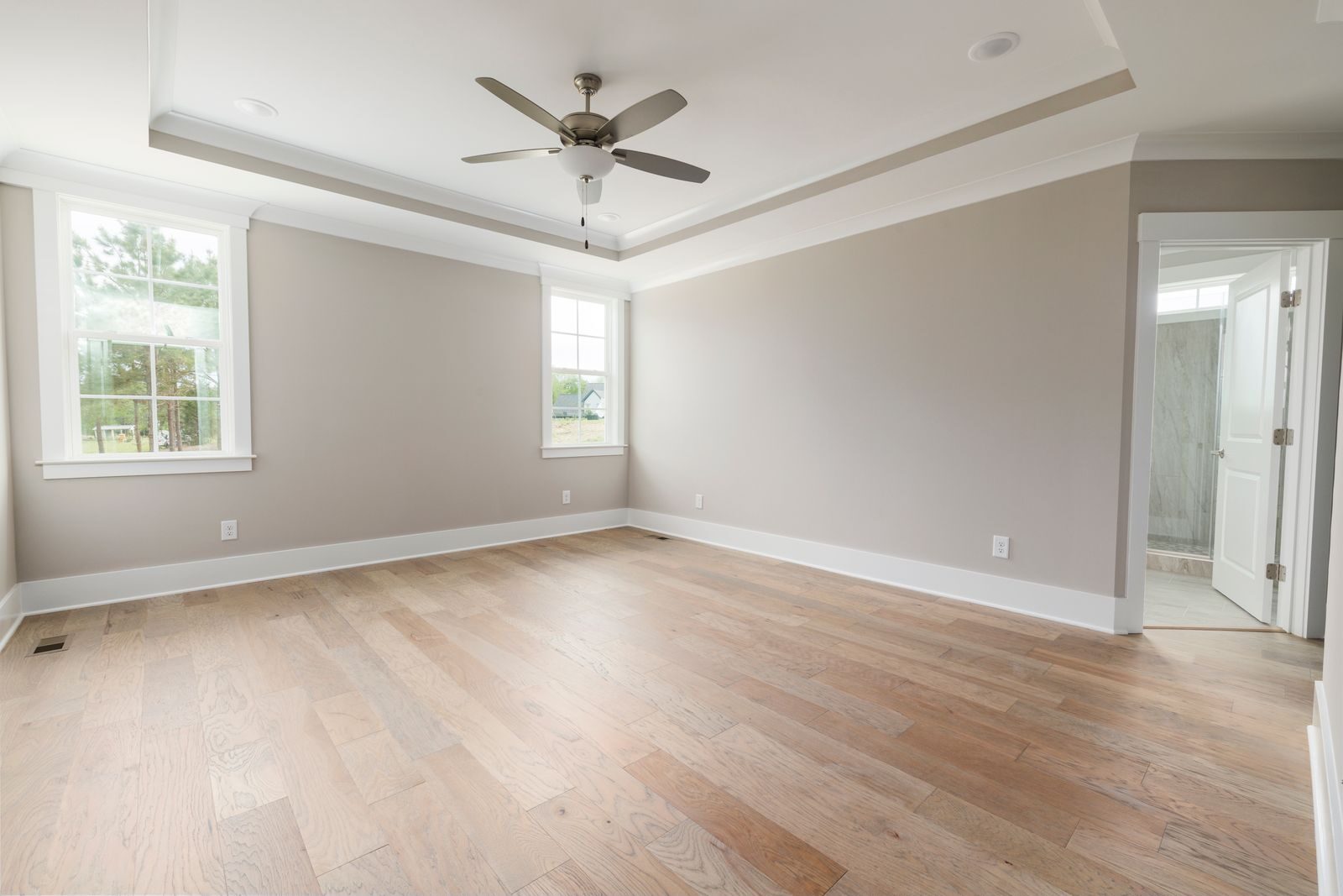 Empty freshly painted room with ceiling fan and open windows
