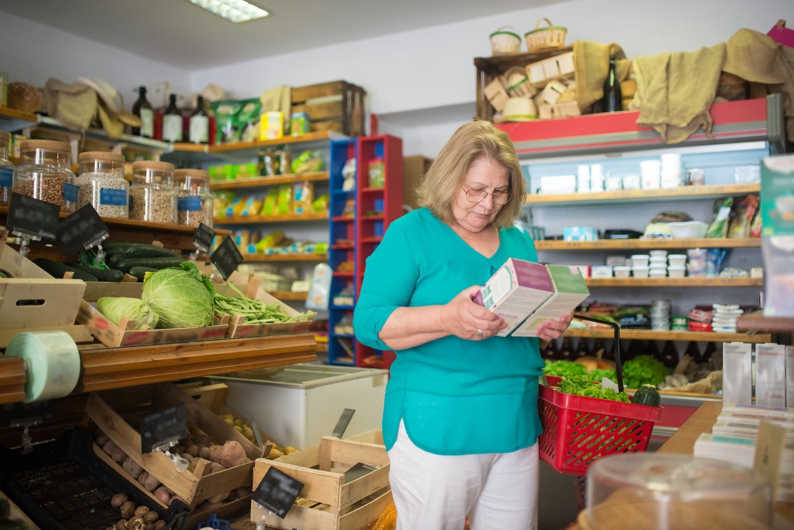 A shopper reading the label on a product in a shop before buying