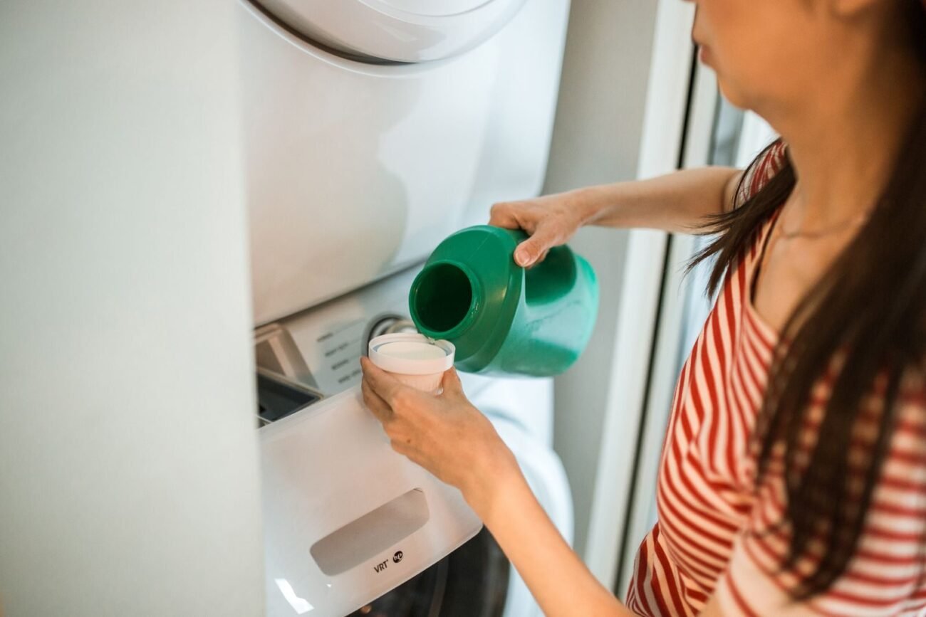 Laundry detergent being poured into a cap by a washing machine, the everyday product people ask about biodegrading